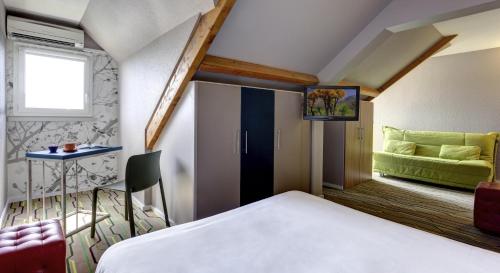 a hotel room with a bed and a couch at ibis Styles Périgueux Trélissac in Trélissac