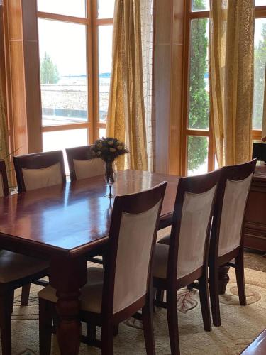 a dining room table with chairs and a large window at Orsetto in Sevan