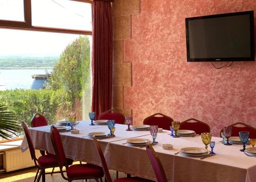 a dining room with a table with chairs and a television at Orsetto in Sevan