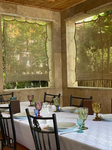 a dining room with tables and chairs and two windows at Orsetto in Sevan