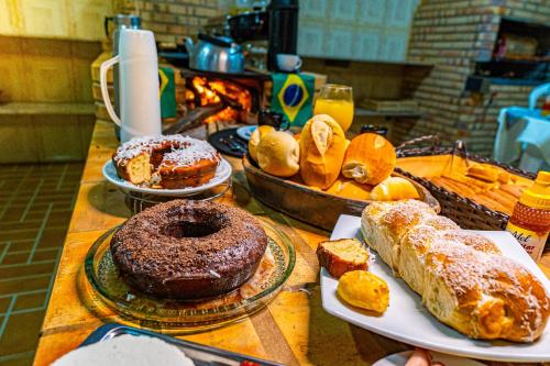 a table with several different types of pastries and bread at Pousada Casarão na Serra in Vargem Bonita