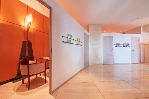 a hallway with orange walls and a table and a mirror at Rembrandt Premium Fuji Gotenba in Gotemba