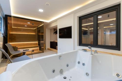 a large white bath tub in a bathroom at President Apartman Spa in Vračar (historical)