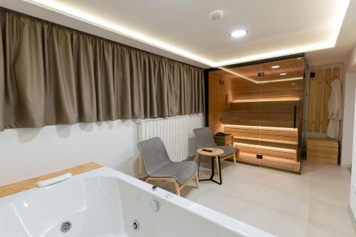 y baño con bañera y silla. en President Apartman Spa, en Vračar (historical)