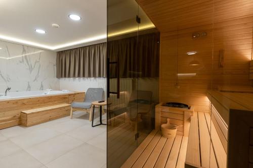 a bathroom with a tub and a table and a chair at President Apartman Spa in Vračar (historical)