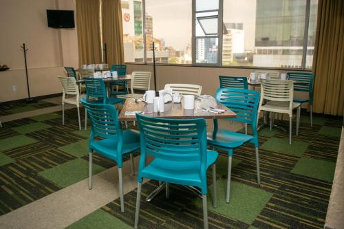 une salle à manger avec des tables et des chaises bleues et une fenêtre dans l'établissement Hotel Del Angel Reforma, à Mexico