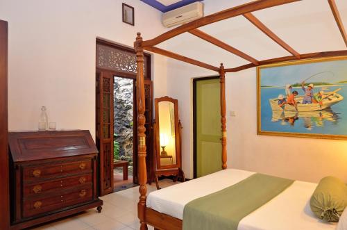 a bedroom with a bed and a dresser at Villa Capers in Colombo