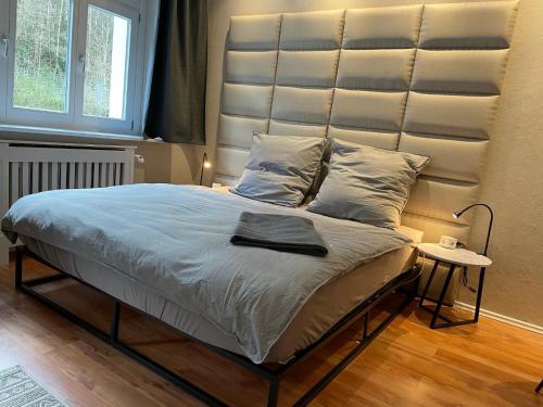 1 cama con cabecero grande en un dormitorio en Bergrauschen - Waldloft - Preise inklusive Wäsche, en Goslar