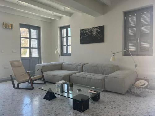 a living room with a couch and a glass table at Stunning 4 bedroom villa on Kastellorizo in Meyisti