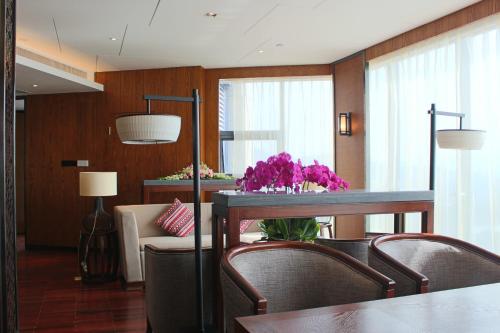 a living room with a table with purple flowers on it at SSAW Boutique Hotel Dexin Mogan Mountain in Deqing