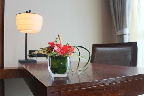 a vase filled with flowers on a wooden table at SSAW Boutique Hotel Dexin Mogan Mountain in Deqing