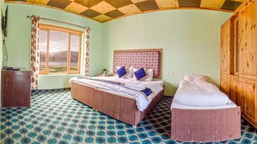 a bedroom with two beds and a window at Tsomoriri Hotel Lake View in Karzok Gömpa