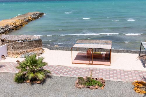 a view of a beach with a gazebo and the ocean at استراحة نادي اورجان Orjan Guest House in Camp