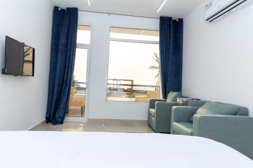 a living room with a couch and chairs and a window at استراحة نادي اورجان Orjan Guest House in Camp