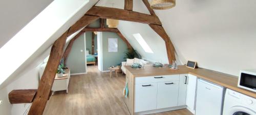 a kitchen with white cabinets and a staircase with wooden beams at Cosy appartement, parking gratuit proche centre in Évreux