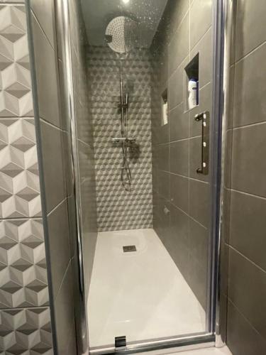 um chuveiro com uma porta de vidro na casa de banho em cocooning et calme a 5 min de l’aéroport em Vitrolles
