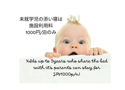 Ein Baby schaut hinter einem Banner raus in der Unterkunft 舞浜1軒家貸切ー最大10名様一駐車場付きMaihama rent-a-house in Urayasu