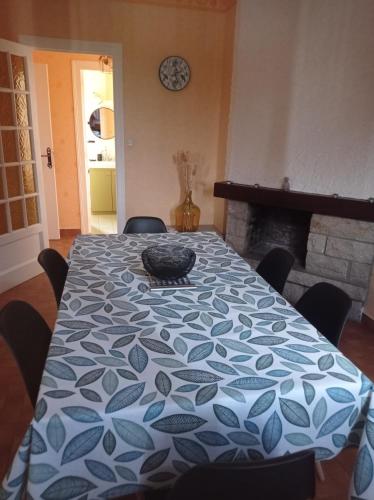 a dining room table with a blue and white table cloth at La maison des Bananiers in Bas-en-Basset