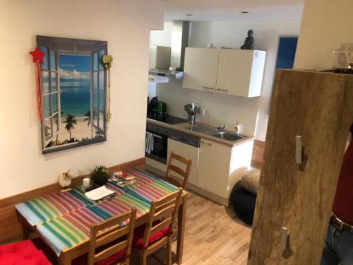 eine Küche und ein Esszimmer mit einem Tisch, einer Küche und einem Zimmer in der Unterkunft Apartment Mischa in Innsbruck