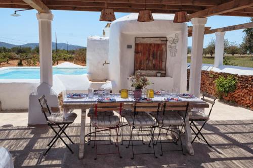 a table and chairs on a patio with a pool at Cas Catalá Sant Jordi in Sant Jordi