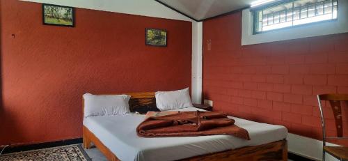uma bolsa castanha sentada numa cama num quarto em Red Carpet Cottage Masinagudi By Lexstays em Masinagudi