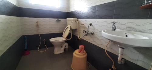 uma casa de banho com um lavatório e um WC em Red Carpet Cottage Masinagudi By Lexstays em Masinagudi