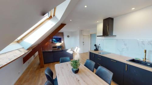 Il dispose d'une cuisine et d'un salon avec une table et des chaises en bois. dans l'établissement Le Corsaire - Face Kursaal et Plage, à Dunkerque