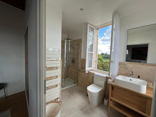 une salle de bain avec un lavabo et des toilettes et une fenêtre dans l'établissement La Madeleine, nichée au cœur de Saint-Émilion, à Saint-Émilion