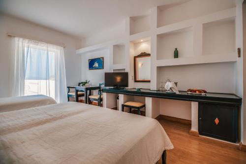 a bedroom with a bed and a desk with a computer at Istron Bay Hotel in Istron