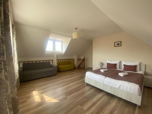 古多里Hotel Donata的一间带床、沙发和窗户的卧室