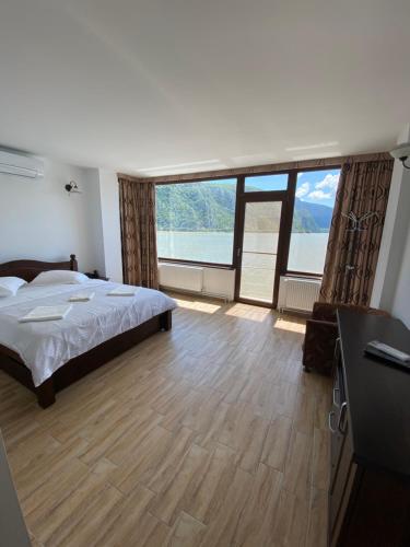 a bedroom with a bed and a large window at Casa Maria Dubova in Dubova