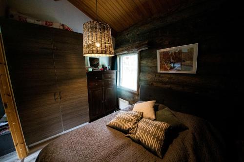 um quarto com uma cama e um lustre em Rukankuukkeli b13 em Kuusamo