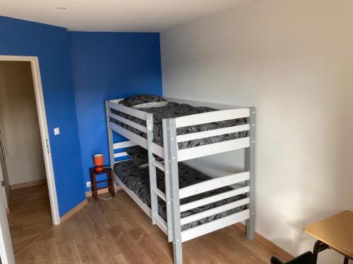 two bunk beds in a room with a blue wall at Gîte de la côte à Autreville sur Moselle in Autreville-sur-Moselle