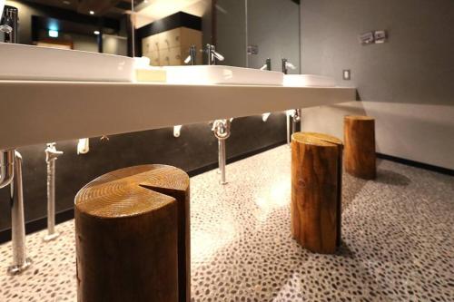 un bagno con un grande lavandino e due sgabelli in legno di MolinHotels201 -Sapporo Onsen Story- 1L2Room S-Bed8 8persons a Jozankei