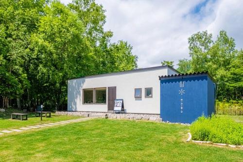 a building with a blue door in a yard at MolinHotels201温泉付き別荘 -アクティビティを満喫できる札幌定山渓-2LDK W-beds2&S-beds4 in Jozankei