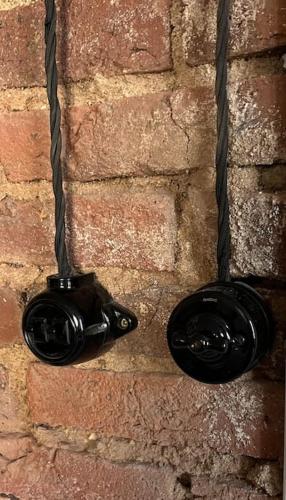 une paire de verres accrochée à un mur de briques dans l'établissement Appartement de charme - Cholet Centre, à Cholet