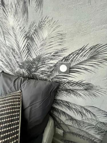 une plante à côté d'un mur avec un oreiller dans l'établissement Appartement de charme - Cholet Centre, à Cholet