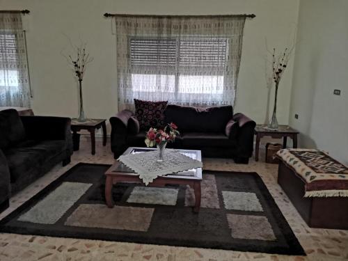 a living room with couches and a coffee table at Alice & Andrew Apt. Few Steps to Madaba Old City Center in Madaba