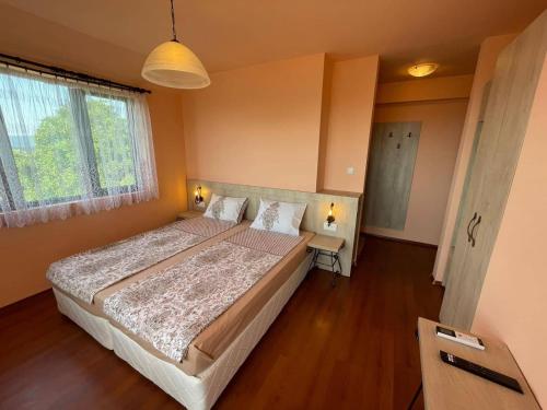 Un dormitorio con una cama grande y una ventana en Комплекс Белла Терра en Gostilitsa