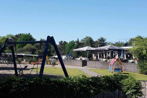 a park with a swing set and a playground at Heerlijk bos chalet met ongekende rust en vrijheid in Nunspeet