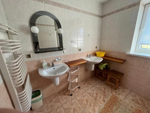 a bathroom with two sinks and a mirror at Agroturystyka Radzewicz in Wiżajny