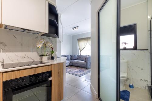 een keuken en een woonkamer met een wastafel en een fornuis bij Lovely 1 Modern bedroom in Waterfall City in Midrand
