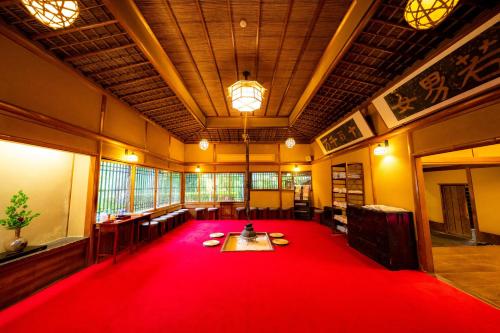 une grande chambre avec un tapis rouge au milieu dans l'établissement Yunoshimakan, à Gero