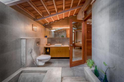 a bathroom with a toilet and a sink at Estate Stay - Riverside Coffee in Siddapur