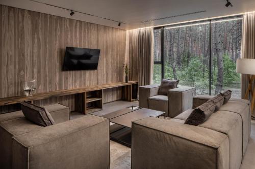 a living room with two couches and a television at Verholy Relax Park in Sosnovka
