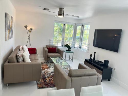 ein Wohnzimmer mit zwei Sofas und einem Fernseher in der Unterkunft Direct Ocean View - Luxurious condo in South Beach in Miami Beach
