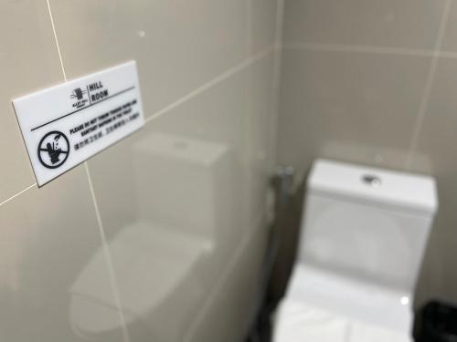 a bathroom with a toilet with a sign on the wall at Alleyhill Phuket - Private & Cozy Boutique in Phuket Town