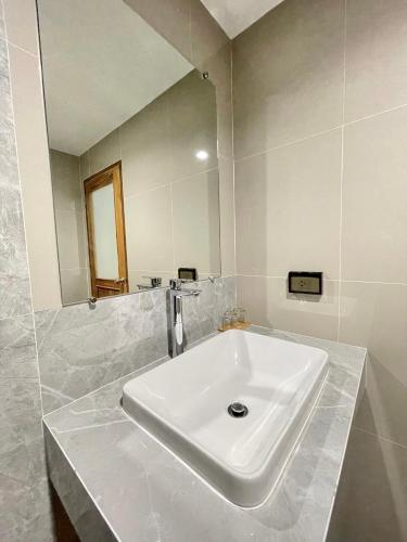 a white sink in a bathroom with a mirror at Alleyhill Phuket - Private & Cozy Boutique in Phuket Town