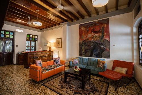 a living room with orange furniture and a painting on the wall at Hotel Penaga in George Town