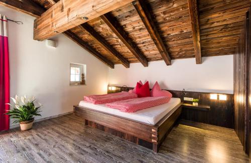 ein Schlafzimmer mit einem Bett mit roten Kissen darauf in der Unterkunft Suite Sinfonie Bergstille in Grän